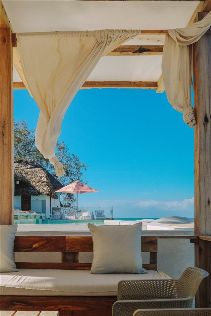 A top-floor suite with draped views over the pool and sea.